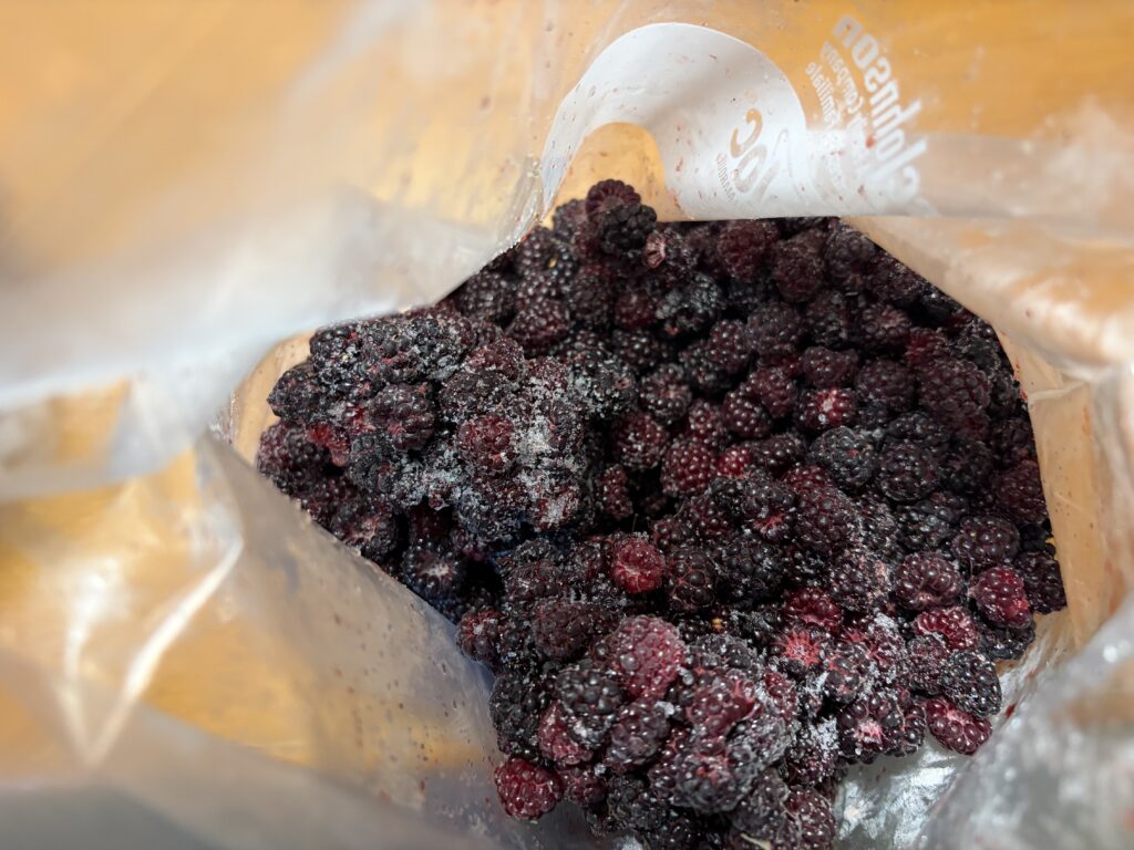 Freezer bag filled with brozen black raspberries